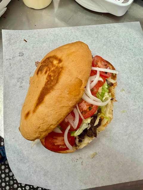 Toasted bolillo torta piled high with meat, fresh tomatoes, red onion, lettuce and avocado